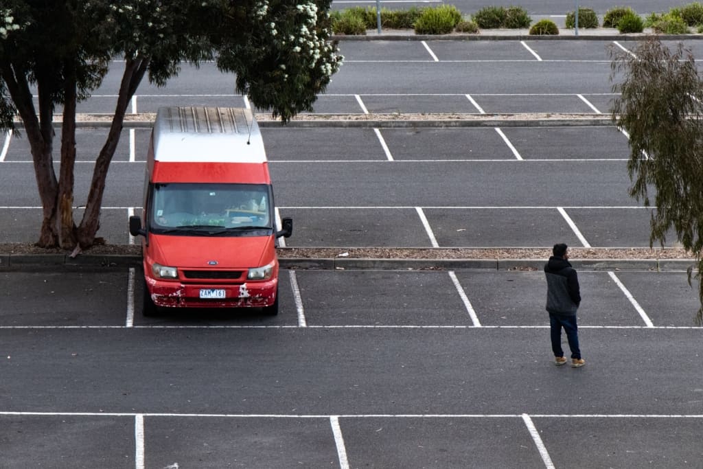 van under tree in shade parking lot