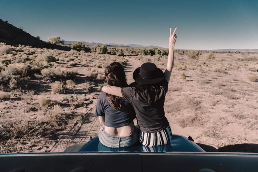 two women sitting on van