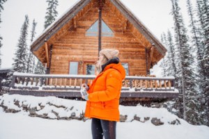 woman outside cabin in winter