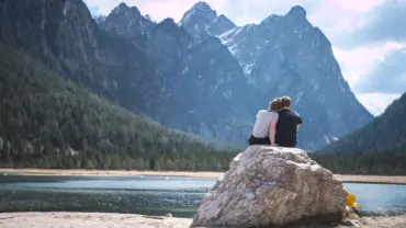 young-couple-outside-sitting-rock-min