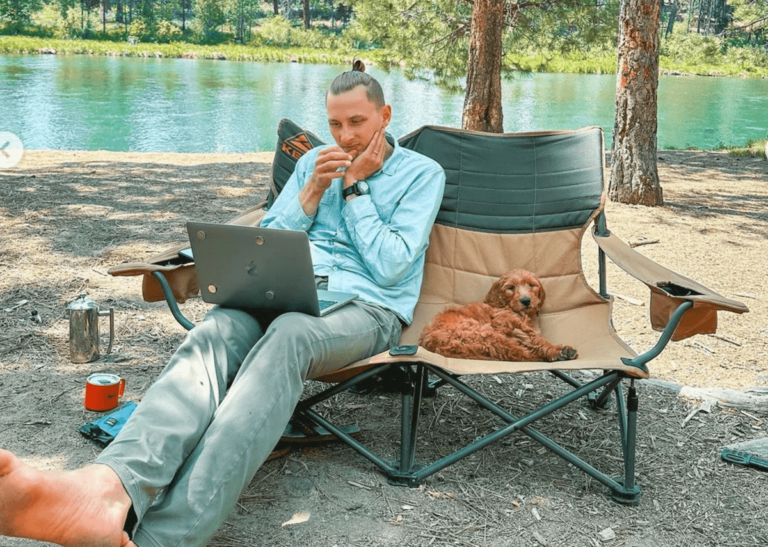 man-working-on-laptop-in-camp-chair-min