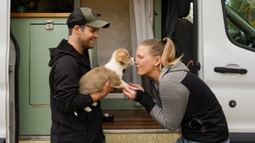 van-life-couple-playing-with-puppy-outside-van